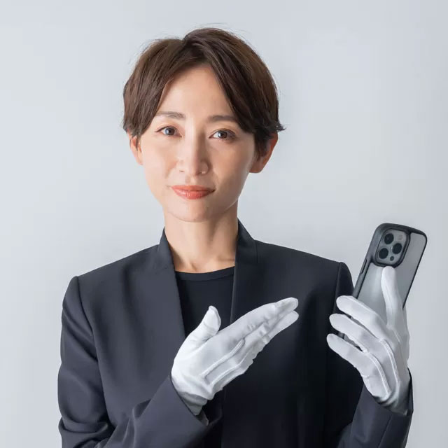熊谷市小さい葬儀受付センターのスタッフが白手袋でスマホを示し「熊谷市 直葬」の案内をする場面